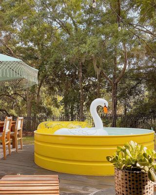 Yellow stock tank pool with an inflatable swan in it