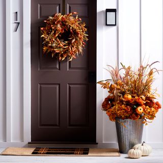 brown door with white walls and flower