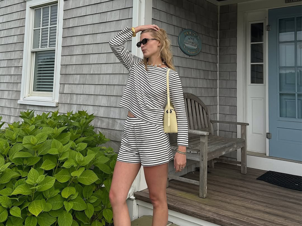 Influencer Lauren Nelson wears a striped set with a butter yellow bag and black flip flops.