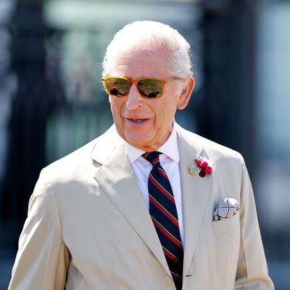 King Charles in a tan suit and sunglasses