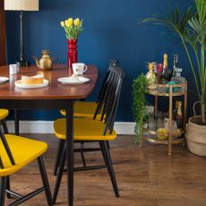 dining area with blue wall and wooden floor and dining table with chairs