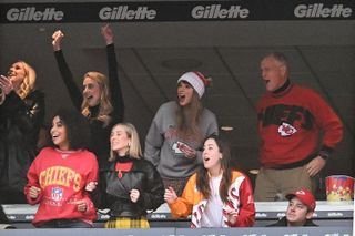 Brittany Mahomes (back row 2nd L), Taylor Swift, and Scott Swift cheer while watching the game between the Kansas City Chiefs and New England Patriots.