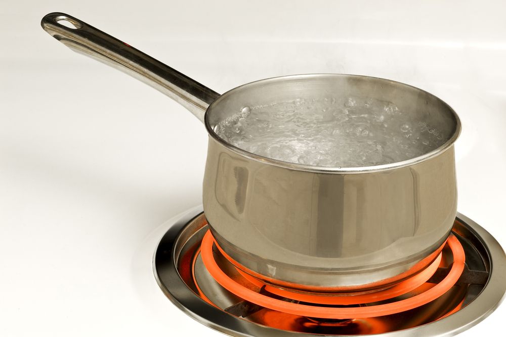 a pot of boiling water shown on a stove top ring