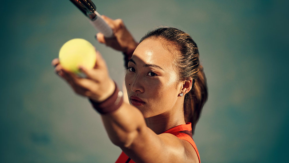 Image of tennis player Qinwen Zheng making a serve from Nike Why Do it? advertising campaign