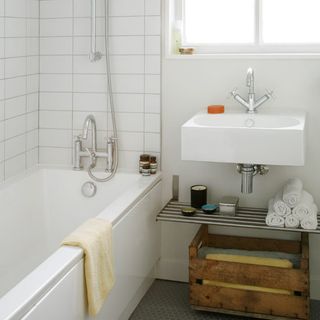 white bathroom with wooden crate and metal shelves