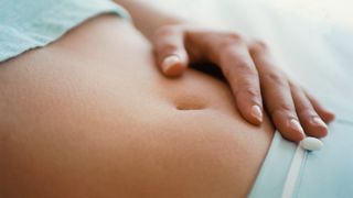 close-up image of woman touching belly