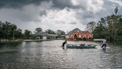 Hurricane Ida: Residents move a boat through a flooded neighborhood on August 31, 2021 in Barataria, Louisiana. Many stores remain closed and services suspended as power throughout New Orleans and its surrounding region is down