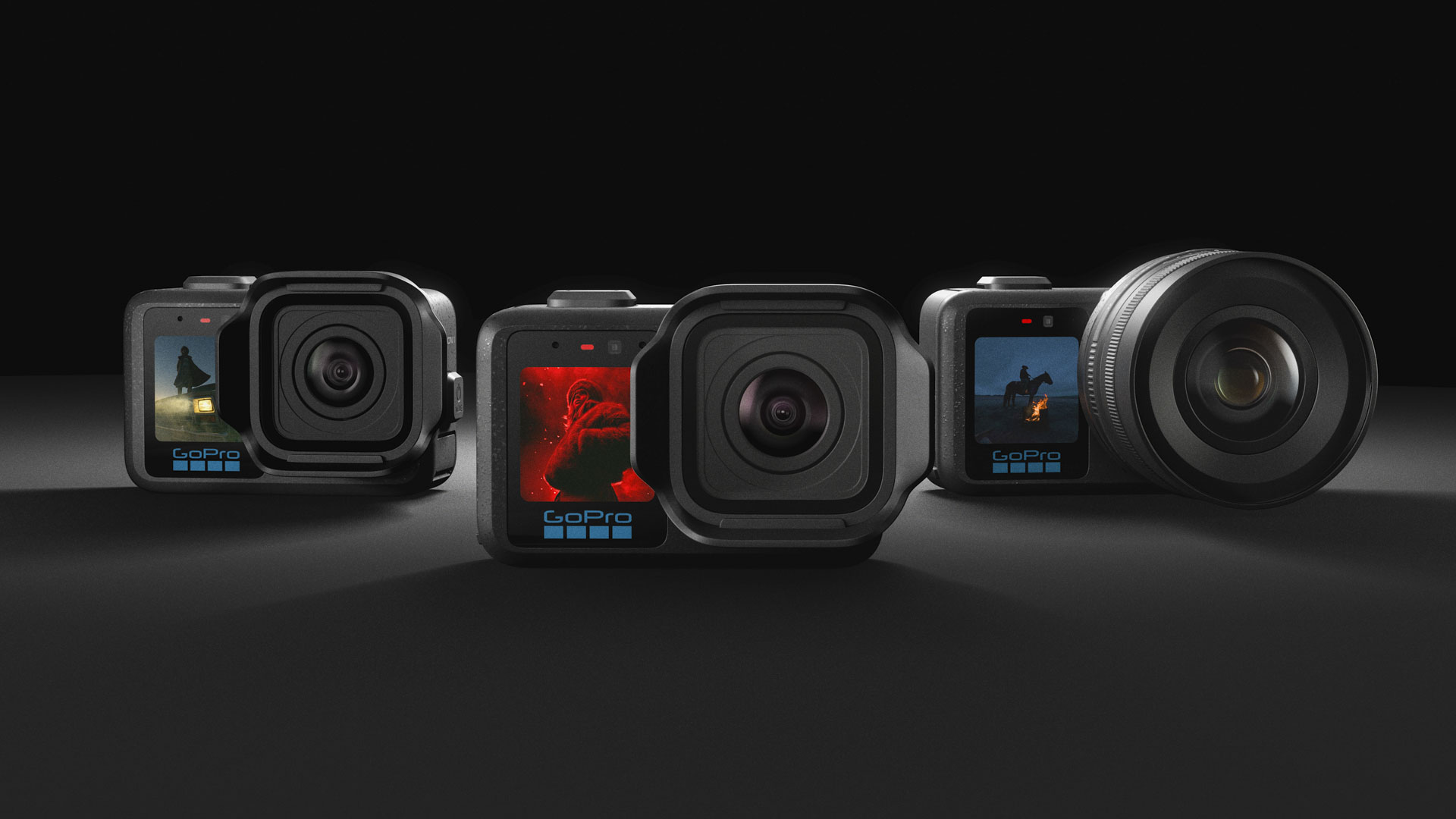 All three of the GoPro Mission 1 series of action cameras side by side over a dark studio background