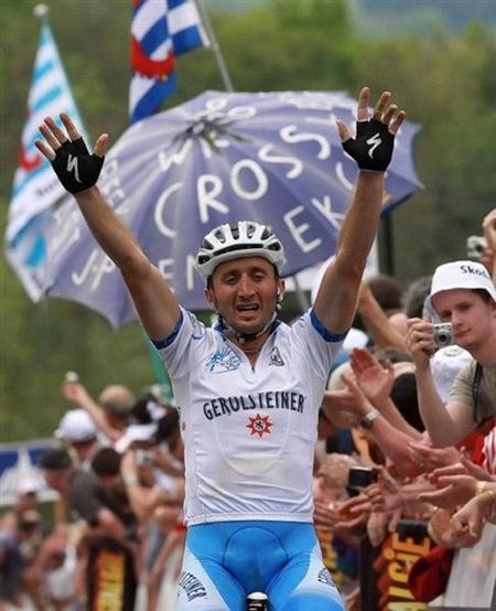 An exhausted Rebellin raises his arms in victory