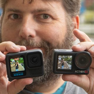 Adam Juniper holding a GoPro Hero 13 Black and a DJI Action 5 Pro