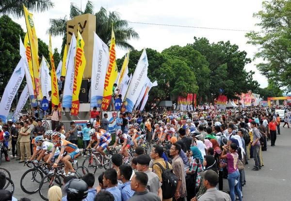 The driver drove at full speed after the start Stage 3 Tour de Singkarak 2012 in Payakumbuh through Monument Adipura Kencana Payakumbuh city pride.