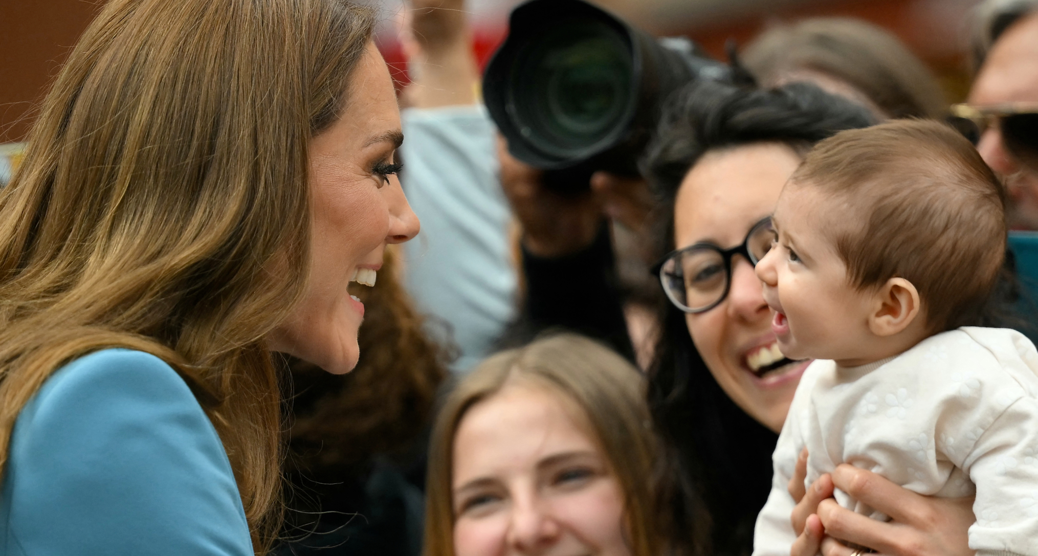 Princess Kate smiling at a baby