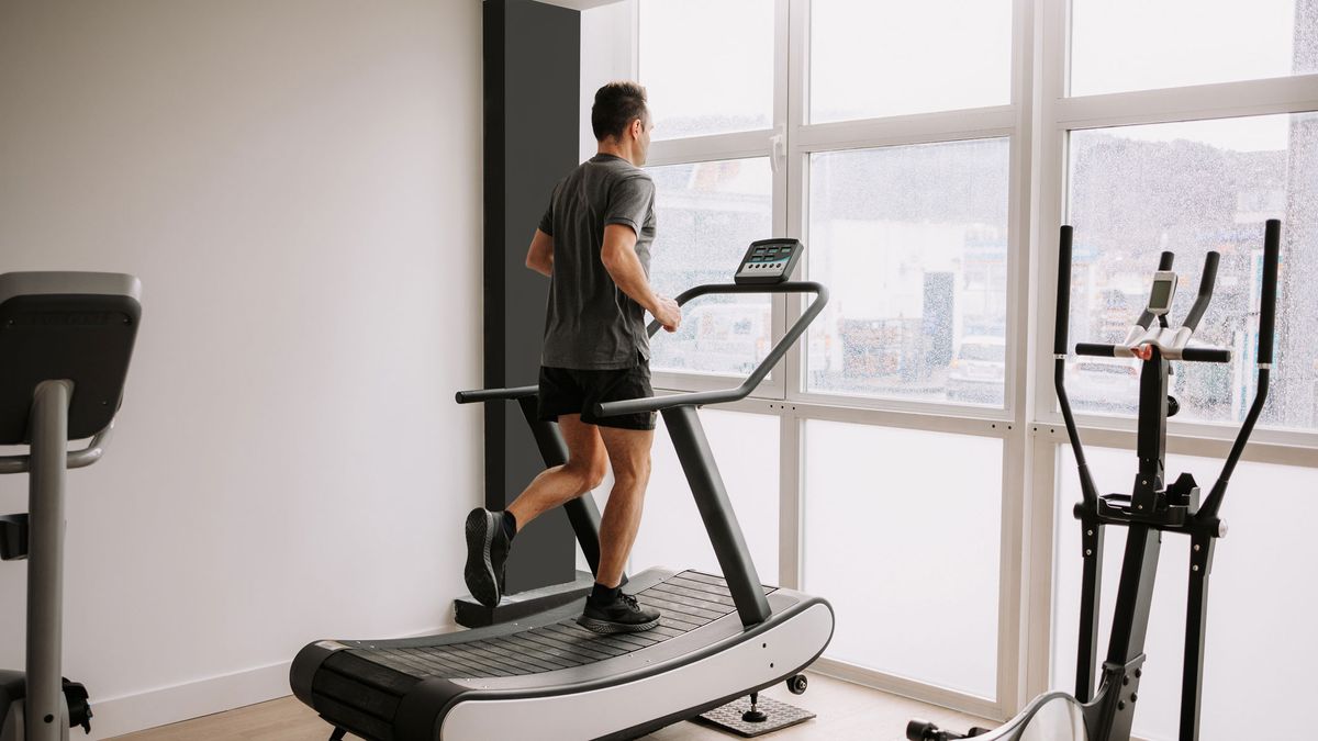 A picture of a man exercising on a treadmill in a home