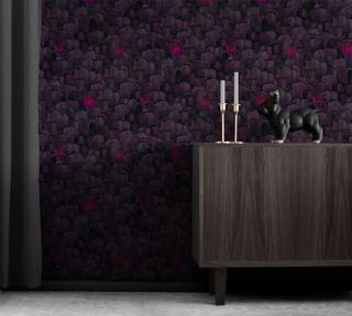 A purple wallpaper with a wooden cabinet kept in front of it
