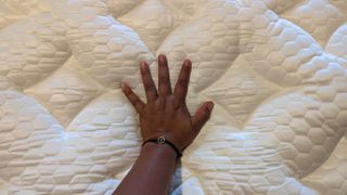 A hand pressing down on the Brooklyn Bedding Signature Hybrid with Cloud Pillow Top mattress