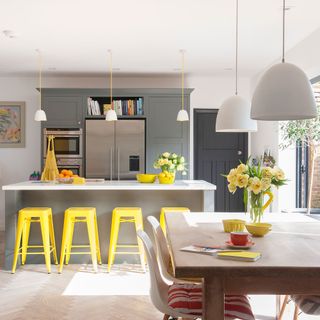 kitchen with white walls and yellow bar stools