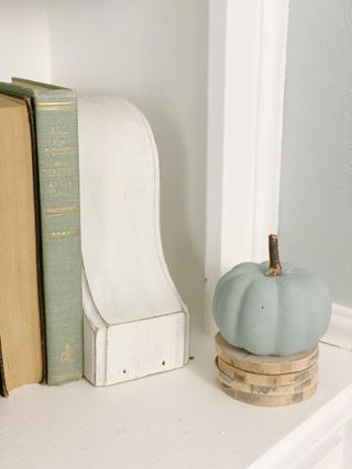 Chalk painted pumpkin with real stem on stacked coasters for display