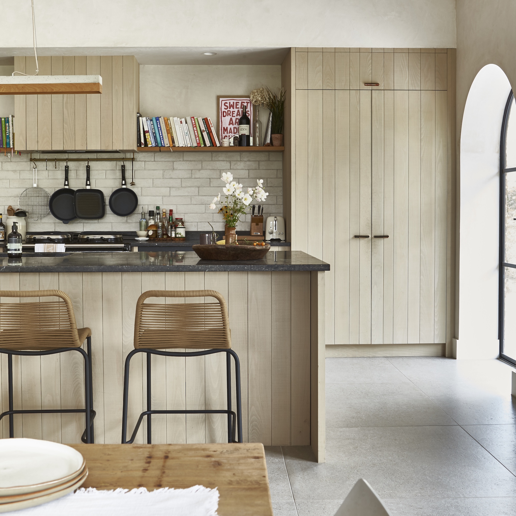 modern farmhouse style kitchen with wooden kitchen with large island and arched patio doors
