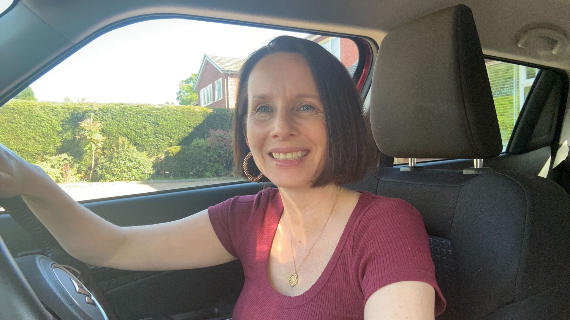 Michelle Rowley behind the wheel of her car, smiling