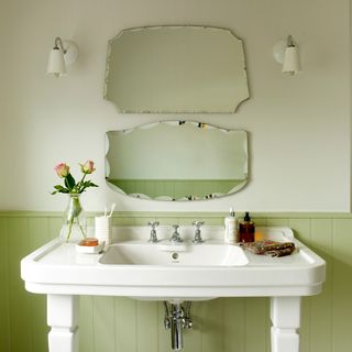 two tone green bathroom with two bevelled mirrors