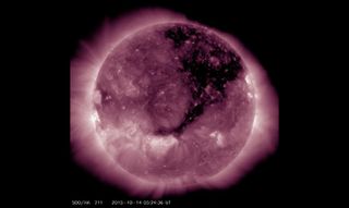 A Solar Dynamics Observatory image published by the National Oceanic Atmospheric Administration reveals the huge coronal hole as it was yesterday. Continuing its march solar west (to the right), the hole is still releasing an extra-fast solar wind in Earth's direction.