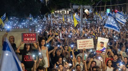 Protesters with flashlights on their phones during Tel Aviv demonstration