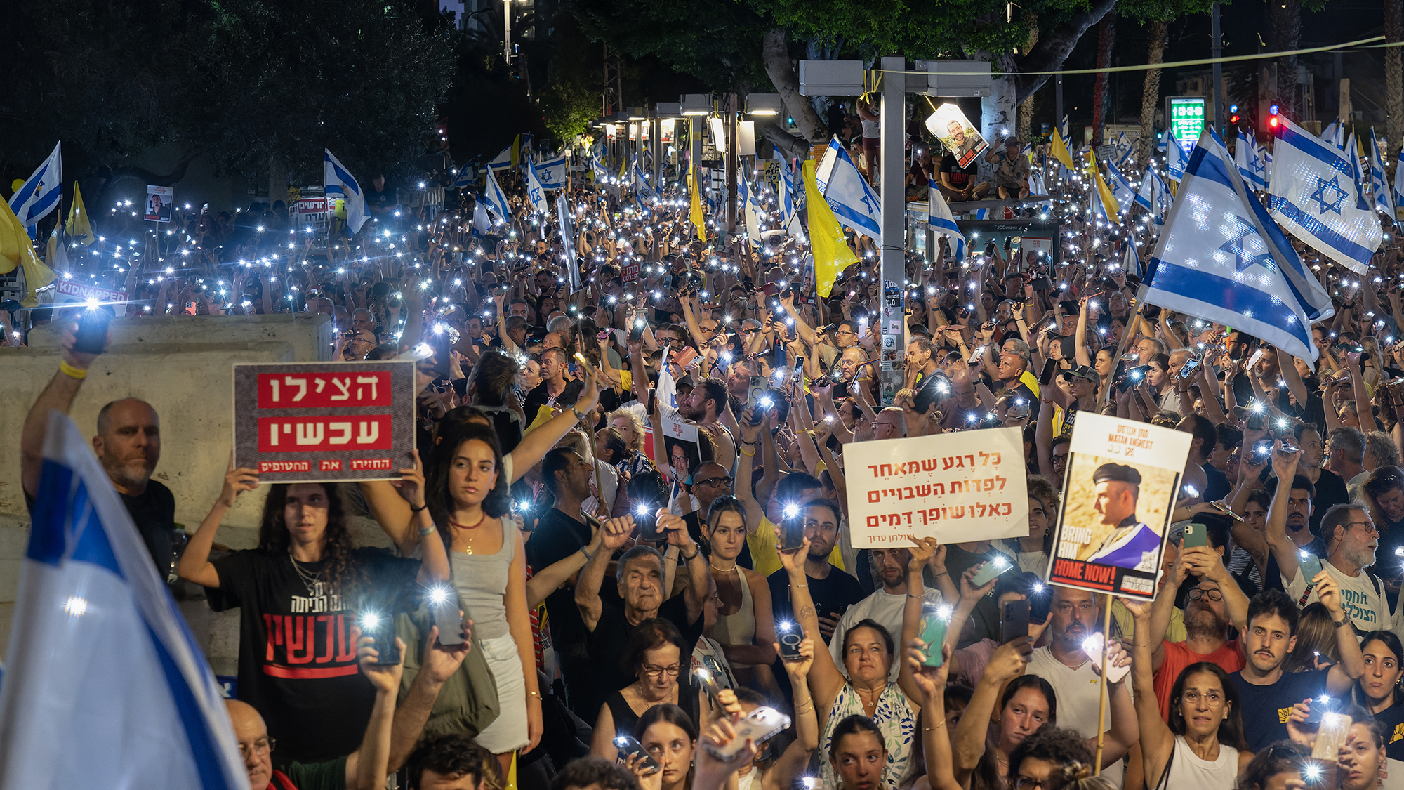 Protesters with flashlights on their phones during Tel Aviv demonstration