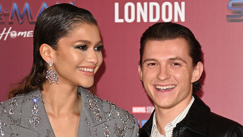 Tom Holland staring at the camera and Zendaya staring into the distance with spider web earrings on at the Spider-Man: No Way Home premiere.