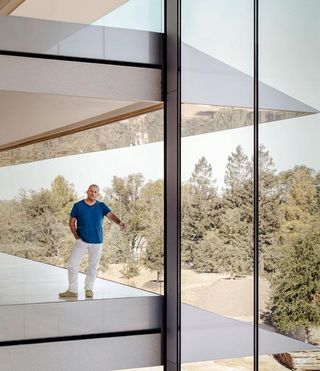 Apple’s chief design officer Jony Ive in the brand’s new HQ, with a glimpse of the 175-acre Apple Park in the background
