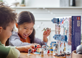 A photo of two children playing with the LEGO Star Wars advent calendar 2022.