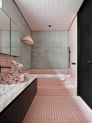 a built in bathtub with pink tiles