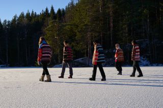 People on ice field in colourful Waste Yarn Project sweater