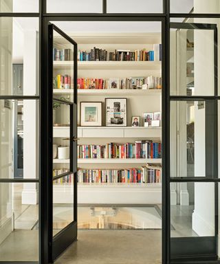 white bookshelves with colourful books and artwork