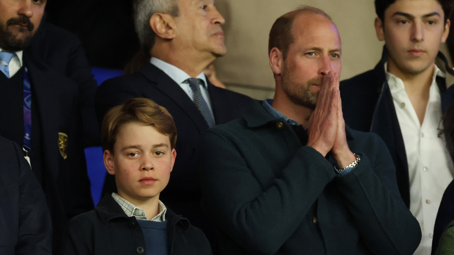 Prince George and Prince William attend a football match