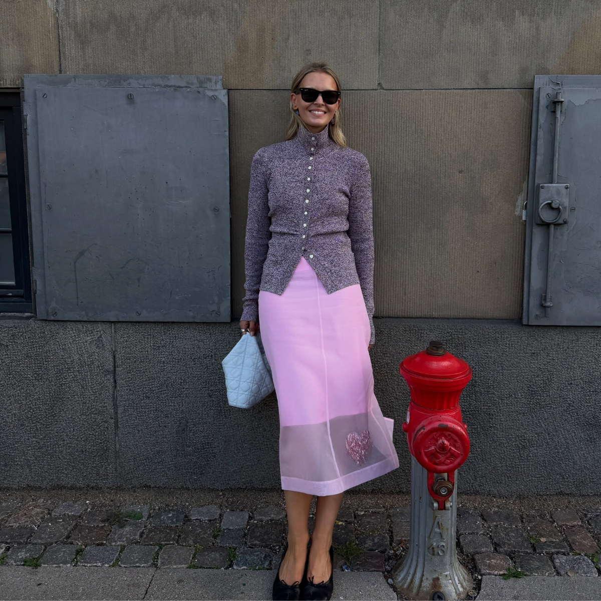 Influencer Hollier Mercedes wearing a turtleneck cardigan, pink sheer skirt and ballet flats. 