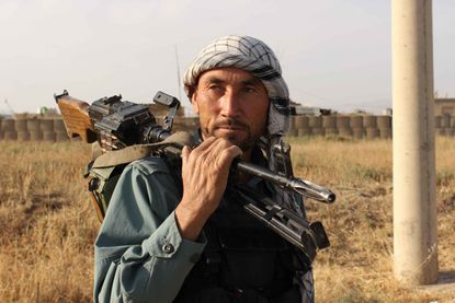 An Afghan police man rests a gun on his shoulder outside Kunduz