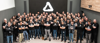 A group shot of the Affinity team in Affinity t-shirts, the large A logo behind them