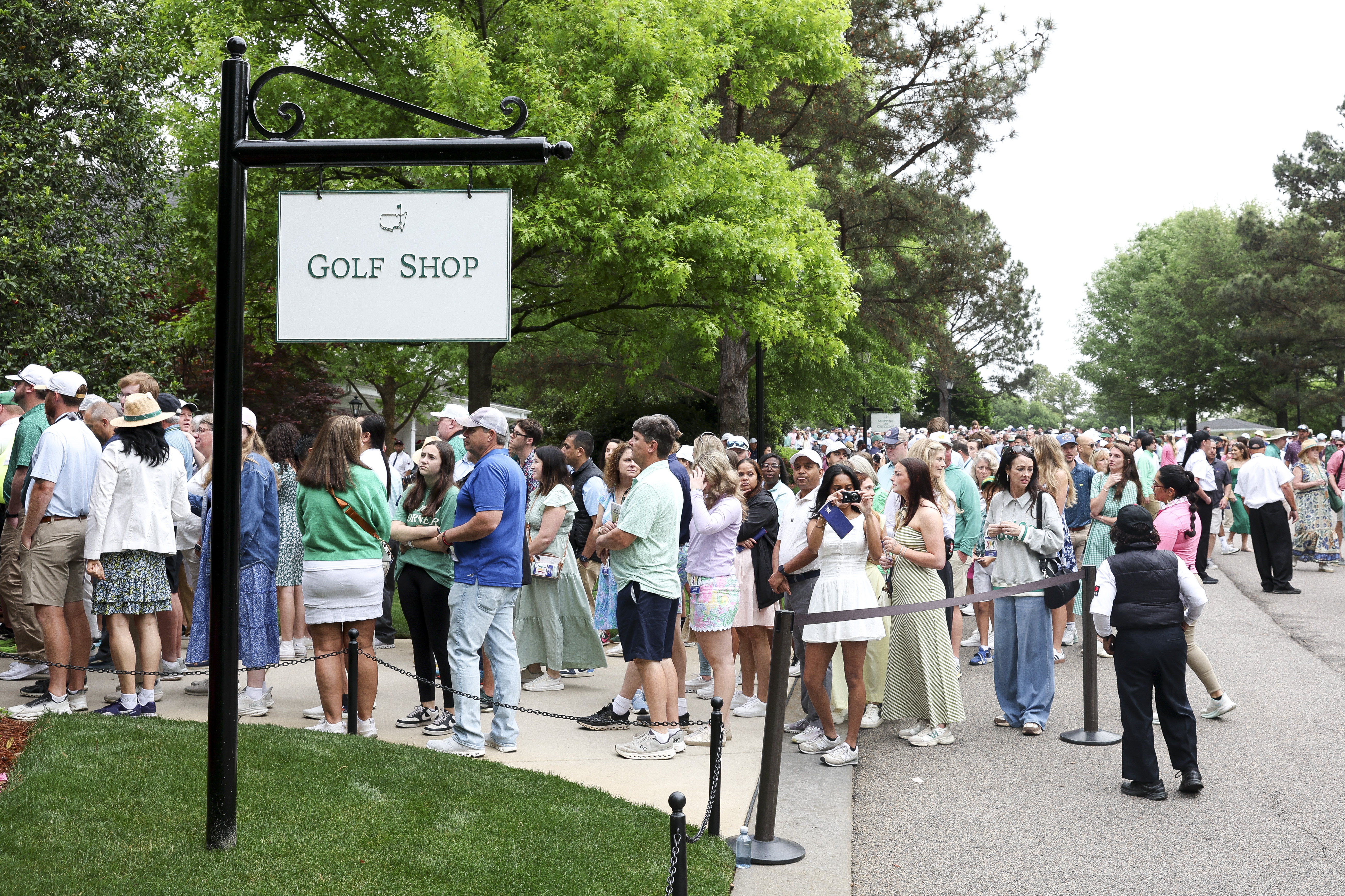 Patrons line up to enter the golf shop during the Drive, Chip and Putt Championship at Augusta National Golf Club