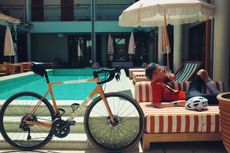 David Bradford lounges poolside sipping a Martini. His bike is in the foreground in front of the pool