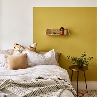 bedroom with yellow wall and brass coloured side table