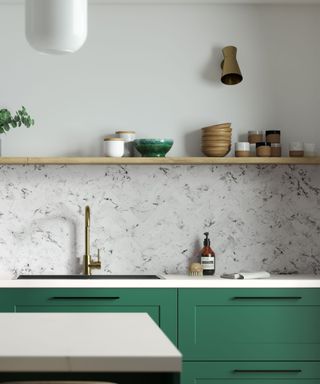 A kitchen with a marble splashback, green cabinets, and a kitchen island
