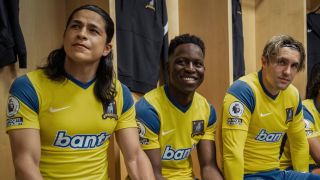 From left to right: Cristo Fern&aacute;ndez, Toheeb Jimoh, and Phil Dunster wearing yellow Richmond jerseys in Ted Lasso. 