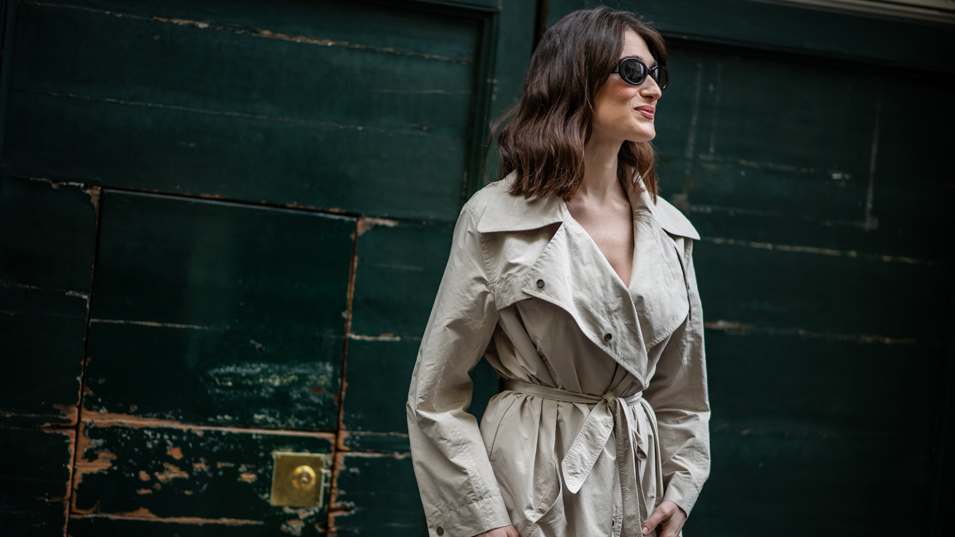fashion week attendee wearing sunglasses and trench coat