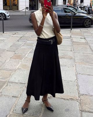 Sophisticated Fashion Trends: @sylviemus wears a full black knitted skirt with a white high-neck knit top and black mules