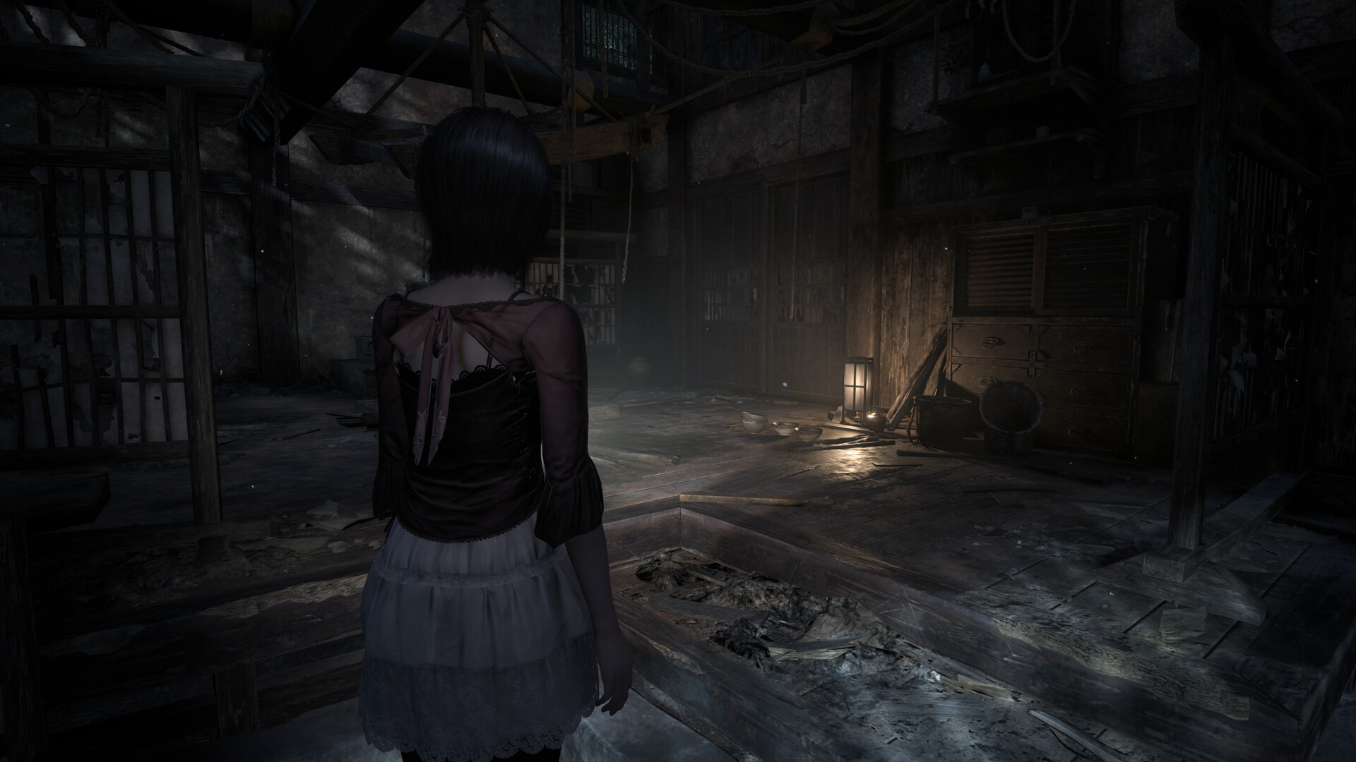 A Fatal Frame 2: Crimson Butterfly Remake screenshot showing the protagonist Mio navigating around a ruined house.