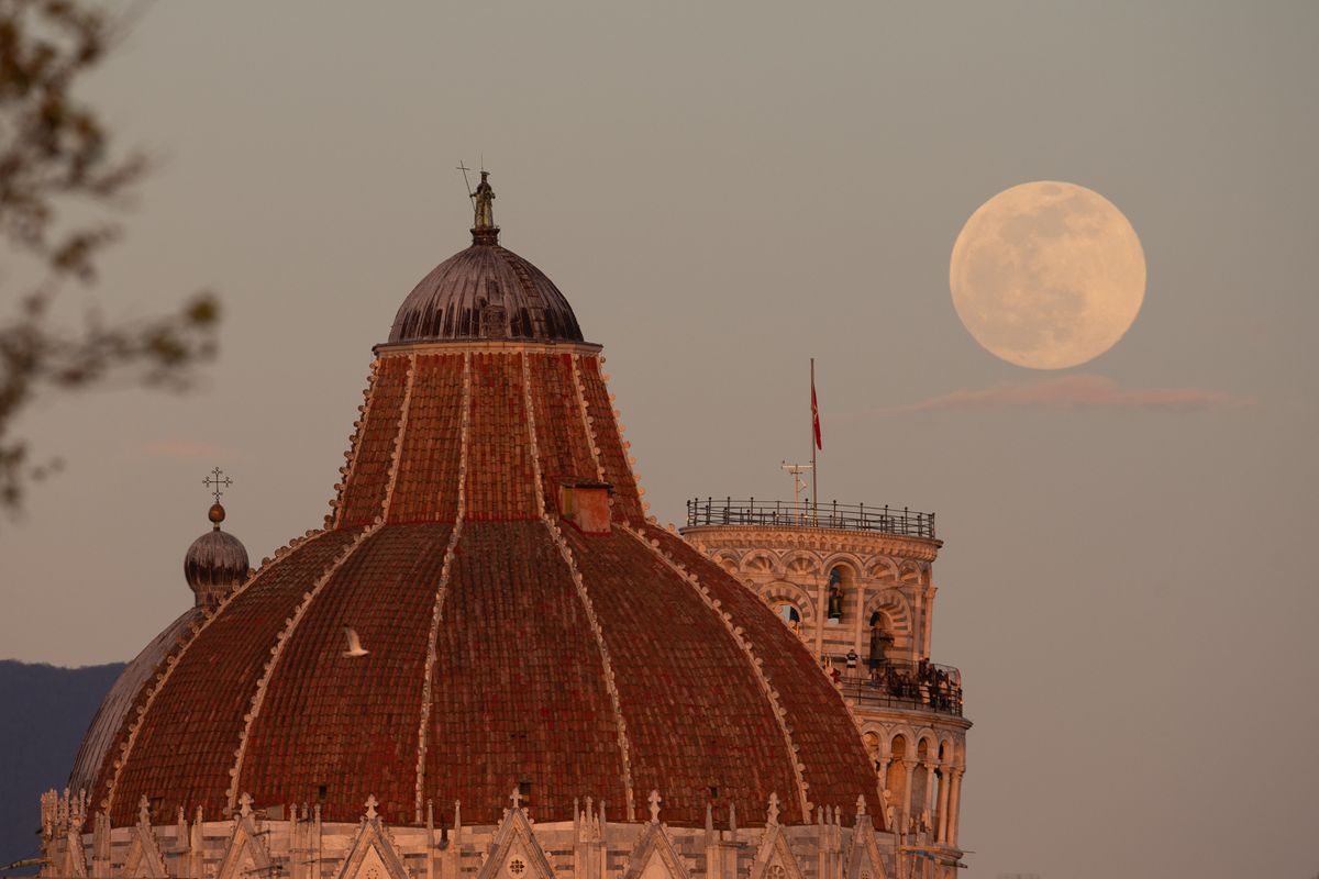 Full moon rises above Pisa Tower (Torre de Pisa) and Baptistery in Pisa, Tuscany, Italy.