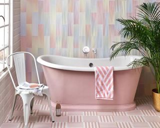 Pink pastel bathtub, patterned tiles, and pastel wallpaper