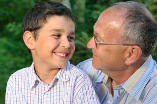 Smiling dad or grandfather with young boy.