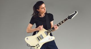 Laura Cox photographed with her white Gibson Firebird