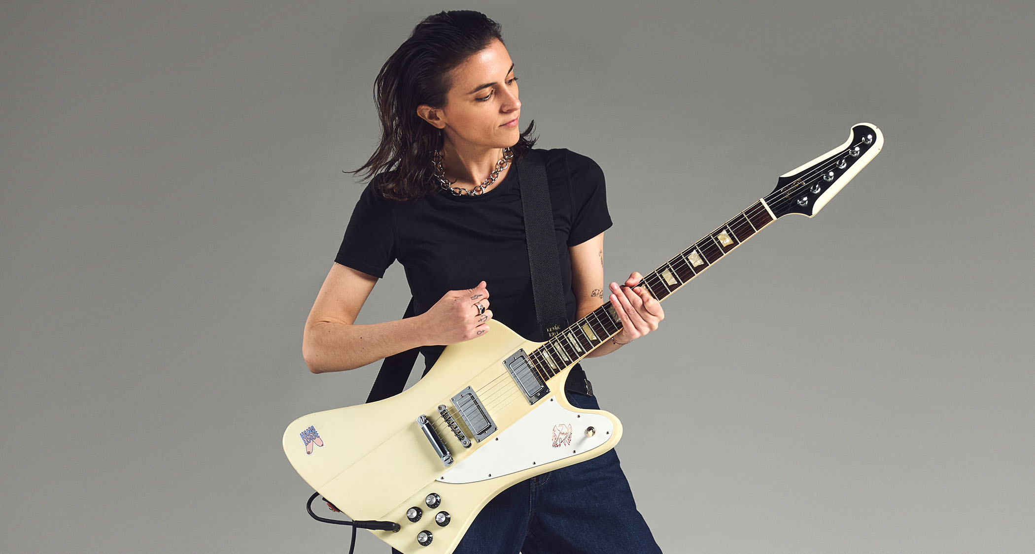 Laura Cox photographed with her white Gibson Firebird